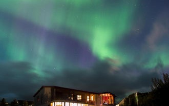 绚丽的极光点亮冰岛南部Stora-Mork家庭旅馆上空的冬夜星空。