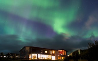 A beautiful display of aurora illuminates the winter skies above Stora-Mork Guesthouse in South Iceland.