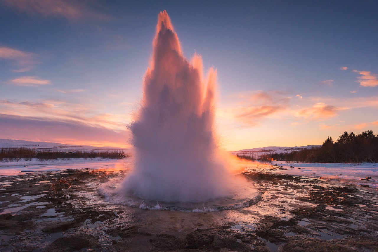 Strokkur-gejsern som sprutar vid soluppgången på Gyllene Cirkeln under vintern, lättillgänglig på en 5-dagars Islandsvistelse.