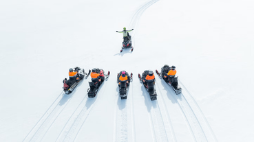 An aerial view of a group of snowmobile riders on Langjokull Glacier.