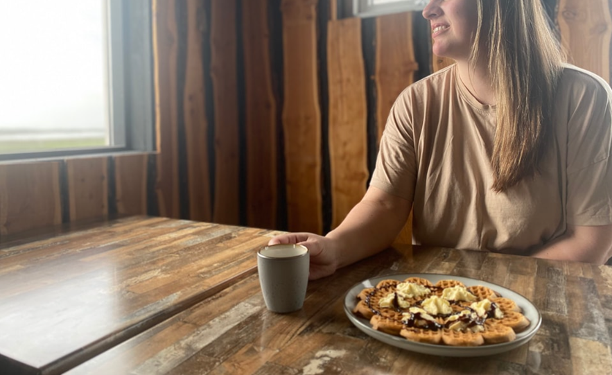 Guest enjoying Icelandic waffles with whipped cream and coffee at the Viking Café on the Stokksnes Peninsula.
