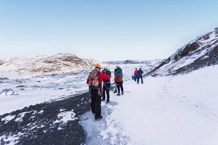 A group of travelers glacier hiking on the icy landscape of Solheimajokull.