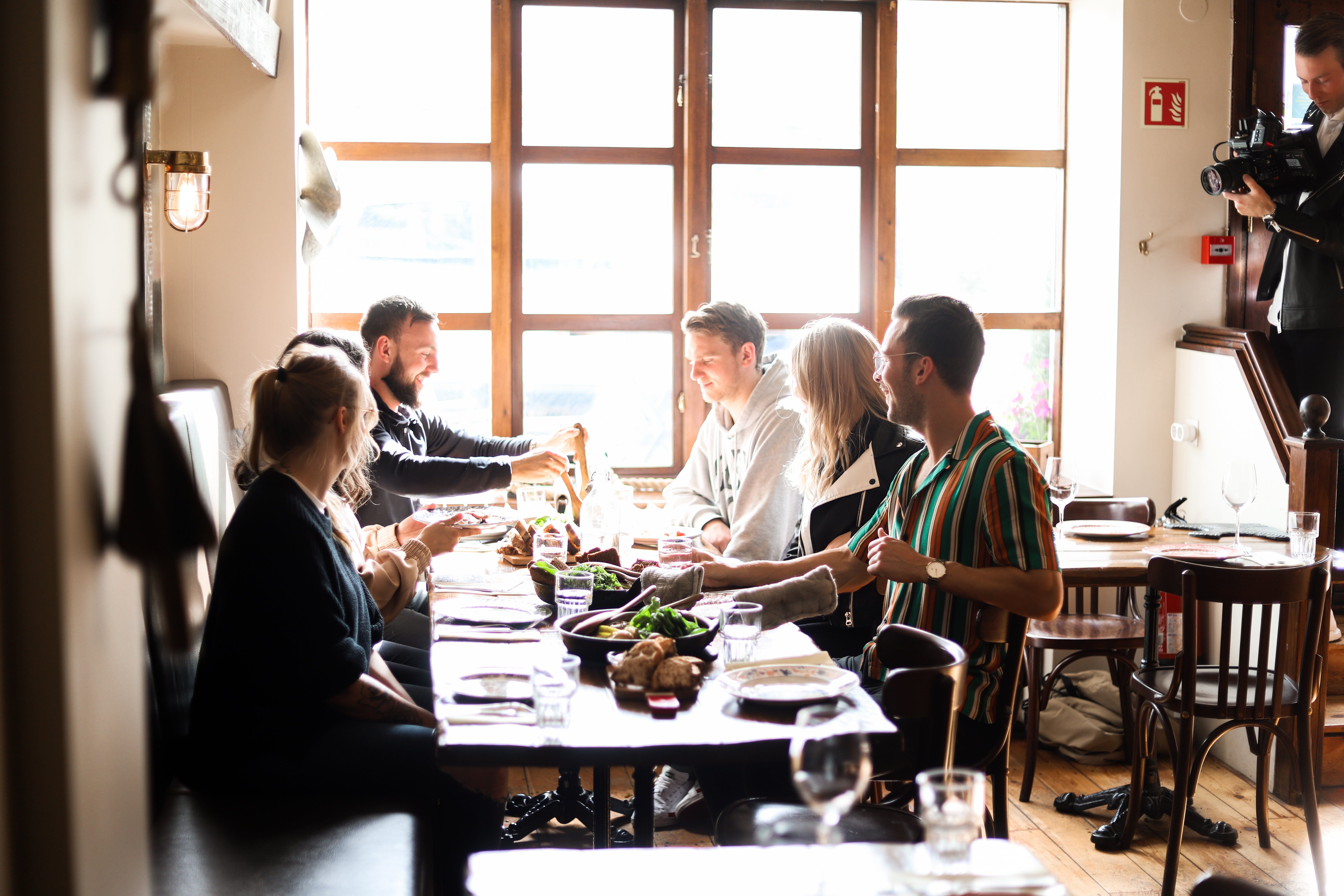 A group of travelers dining in a restaurant during a food walking tour in Akureyri.