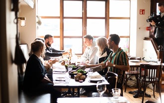 A group of travelers dining in a restaurant during a food walking tour in Akureyri.