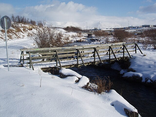A snow-filled Ellidaa pedestrian bridge in Ellidaardalur Valley in Reykjavik, Iceland.