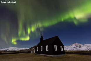 L'église noire de Budir avec les aurores boréales et le Snaefellsjokull en arrière-plan.