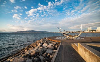De Sun Voyager sculptuur in Reykjavik, IJsland met de haven op de achtergrond.