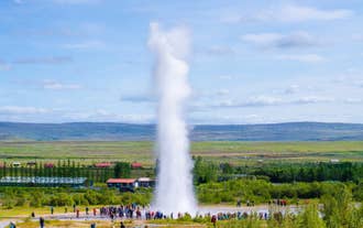 Strokkur Geyser erupting high into the air at the Geysir Geothermal Area, Iceland.