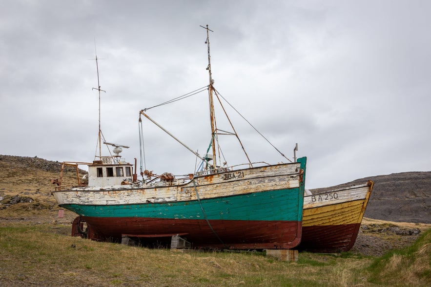 Old Icelandic fishing boats displayed on land near Hnjotur Museum in the Westfjords.