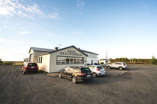 Front view of Hotel Skulagardur with cars parked out front.