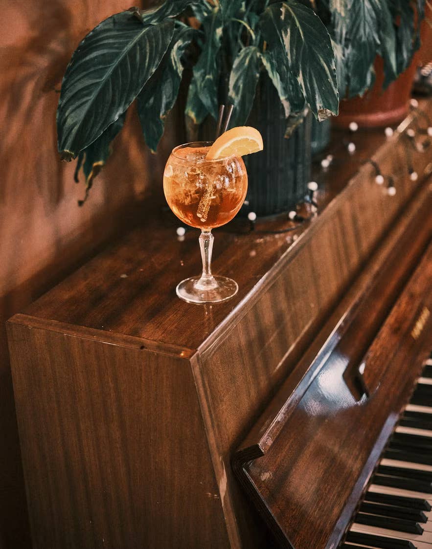 A glass of liquor sitting on top of a wooden piano in Elly Bar in Reykjavik, Iceland. A glass of liquor sitting on top of a wooden piano in Elly Bar in Reykjavik, Iceland.