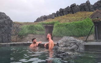 Dwóch mężczyzn relaksuje się w geotermalnym spa Sky Lagoon niedaleko Reykjaviku.