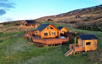 Aerial view of LL Properties | G20 Cabin With Amazing View, a wooden retreat with a wraparound deck set on peaceful grassy hills