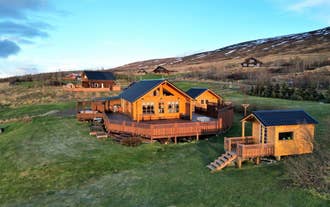 Aerial view of LL Properties | G20 Cabin With Amazing View, a wooden retreat with a wraparound deck set on peaceful grassy hills