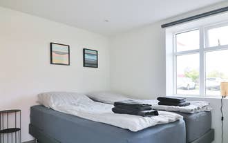 Bright bedroom with two single beds at G7 Akureyri Central Apartments in North Iceland.