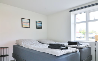 Helles Schlafzimmer mit zwei Einzelbetten in den G7 Akureyri Central Apartments in Nordisland.