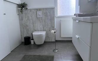 Modern bathroom with wall-hung toilet at M116 Historic Akureyri Apartments.