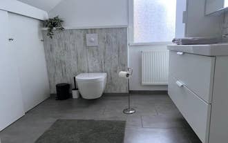 Modern bathroom with wall-hung toilet at M116 Historic Akureyri Apartments.