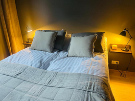 A dark and inviting bedroom with soft lighting from bedside lamps at AK-Lux101 in Akureyri.