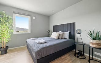 The Serene Summerhouse Near Selfoss offers a cozy double bedroom with countryside views and gray bedding.