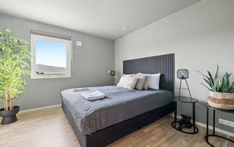 The Serene Summerhouse Near Selfoss offers a cozy double bedroom with countryside views and gray bedding.