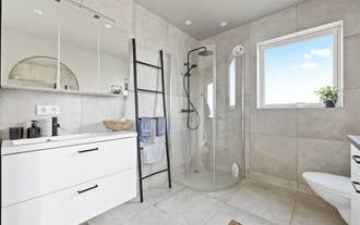 The bathroom at Serene Summerhouse Near Selfoss features a walk-in shower and sleek black fixtures.