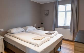 The bedroom at big house with a view in Akureyri has twin beds, white linens, and a window with natural light.