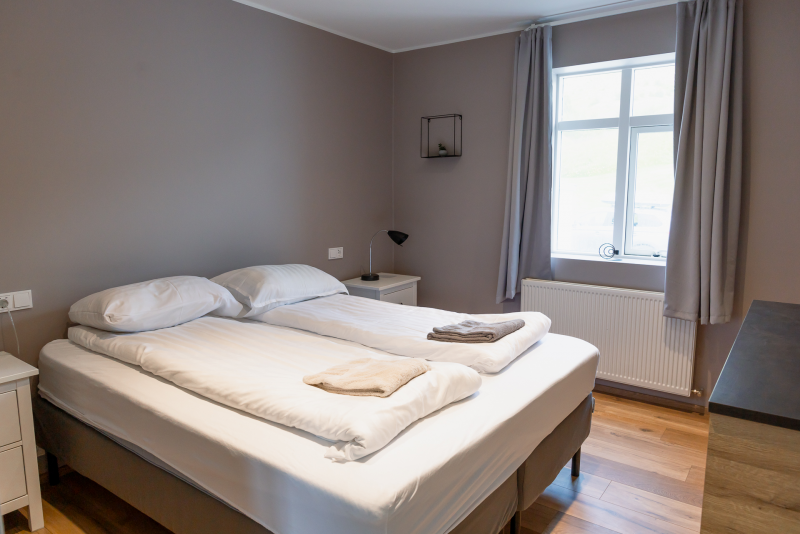 The bedroom at big house with a view in Akureyri has twin beds, white linens, and a window with natural light.