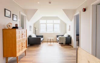 The upstairs lounge at big house with a view in Akureyri has sofas and a large window with fjord views.