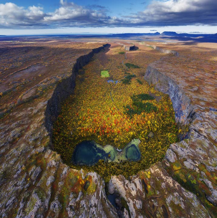 El Cañón Asbyrgi en el norte de Islandia se cubre de vibrantes colores otoñales y está rodeado de acantilados y piscinas naturales.