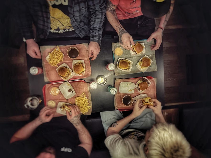 Group enjoying craft burgers, loaded fries, and beer at Brixton.