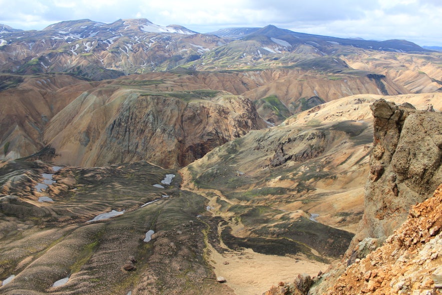 Vista panorámica de las tierras altas de Islandia mostrando montañas volcánicas escarpadas, valles profundos y terreno de riolita colorido cerca de Landmannalaugar Vista panorámica de las tierras altas de Islandia mostrando montañas volcánicas escarpadas, valles profundos y terreno de riolita colorido cerca de Landmannalaugar