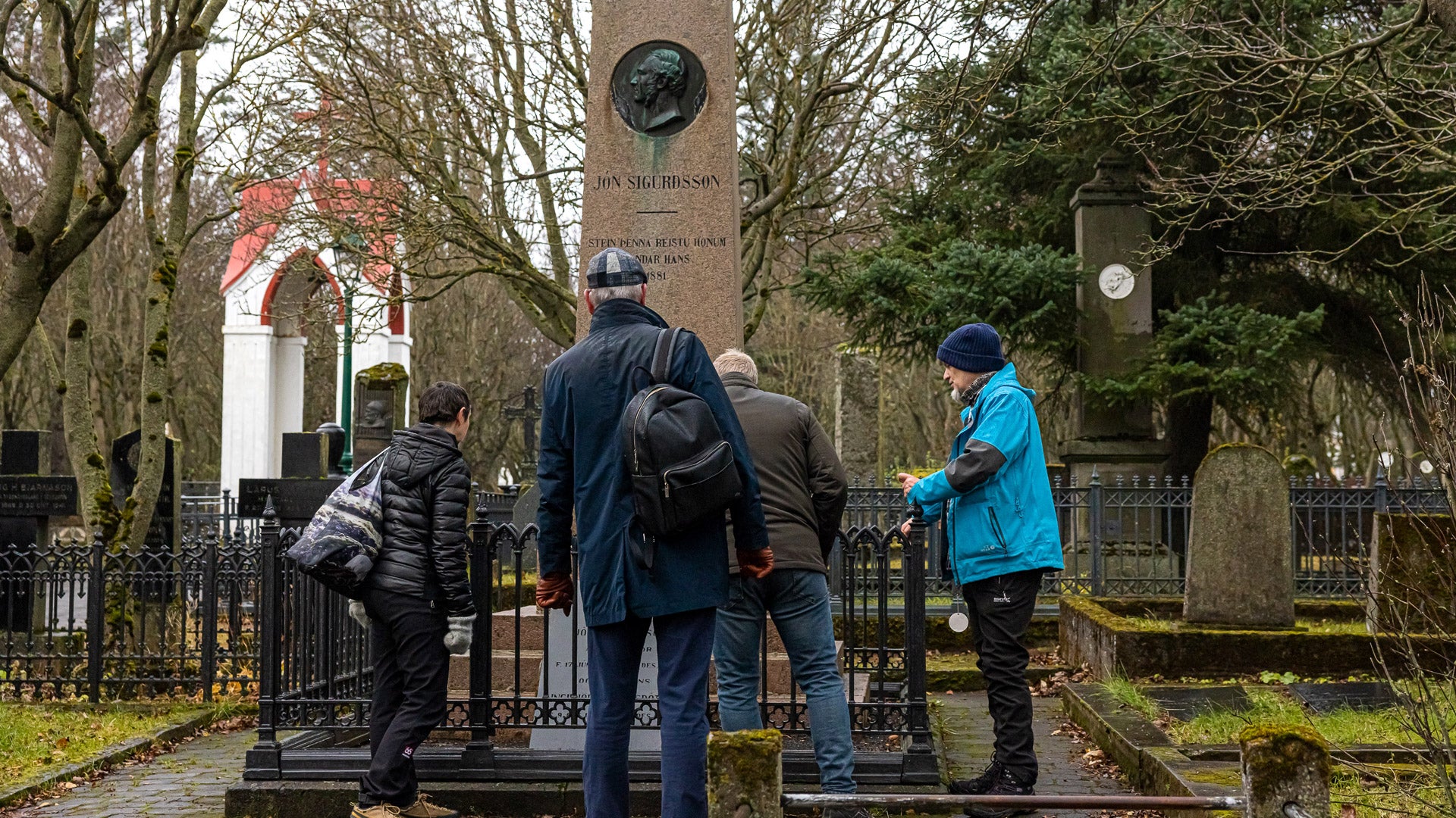 Gæster, der udforsker Jón Sigurdssons grav på Holavallagardur-kirkegården på en byvandring i Reykjavik.