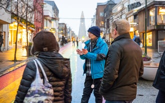 Travelers walking with a local guide along colorful Skolavordustigur Street in Reykjavik.