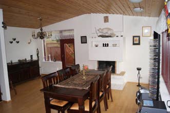 Dining area at Grytubakki 3, with wooden dining table and fireplace in background.