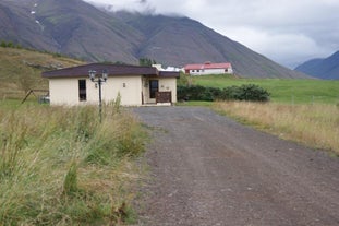 Driveway leading to Grytubakki 3, a quaint yellow cottage in North Iceland with two bedrooms and one bathroom.