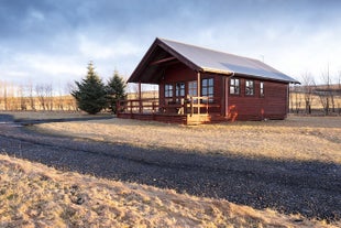 Exterior view of one of the cottages at Smaratun Farm Eco Lodges amid countryside surroundings.