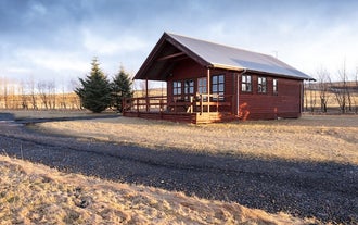 Exterior view of one of the cottages at Smaratun Farm Eco Lodges amid countryside surroundings.