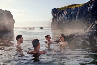 A group of friends relaxing in the thermal waters of Iceland's Sky Lagoon spa.