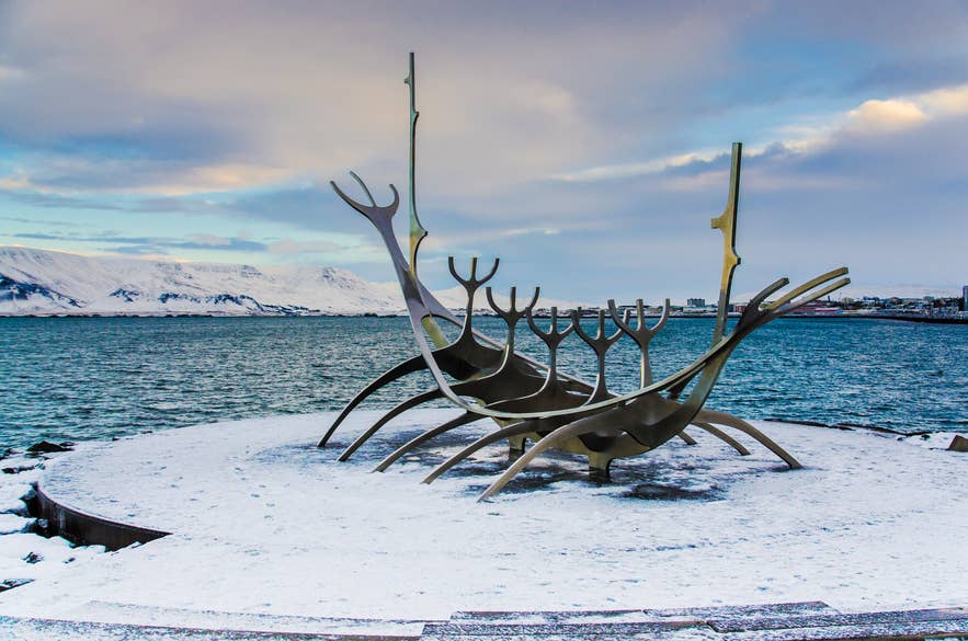 5-Tage-Island-Reise mit der Sun Voyager Skulptur und verschneiten Bergen in Reykjavik.
