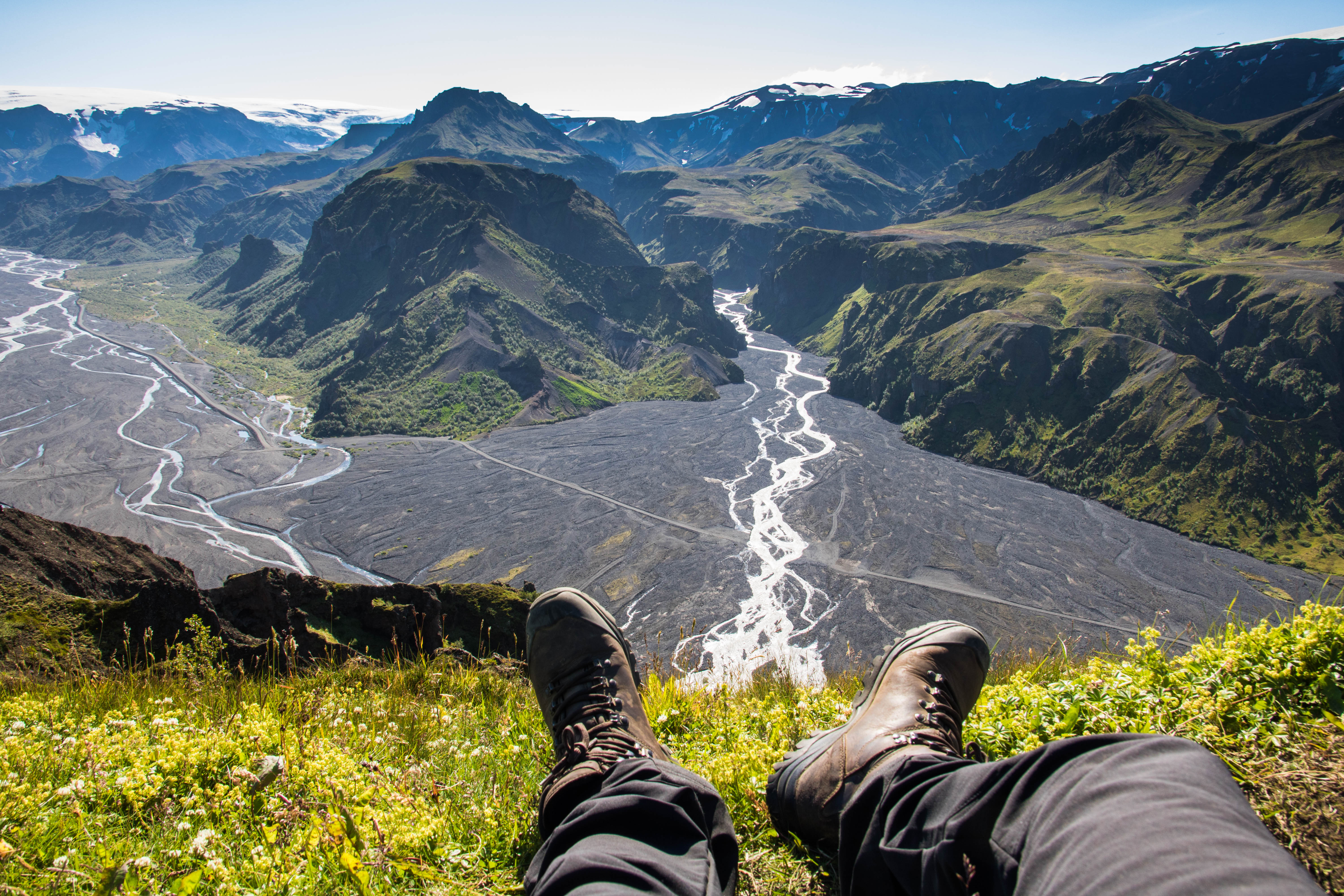 A bird's eye view photo of a hiker's shoes with the mountains below in Thorsmork.