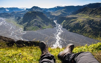 A bird's eye view photo of a hiker's shoes with the mountains below in Thorsmork.