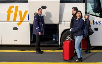 Passagerer går ombord på deres komfortable bus, der kører dem til eller fra Keflavik Lufthavn.