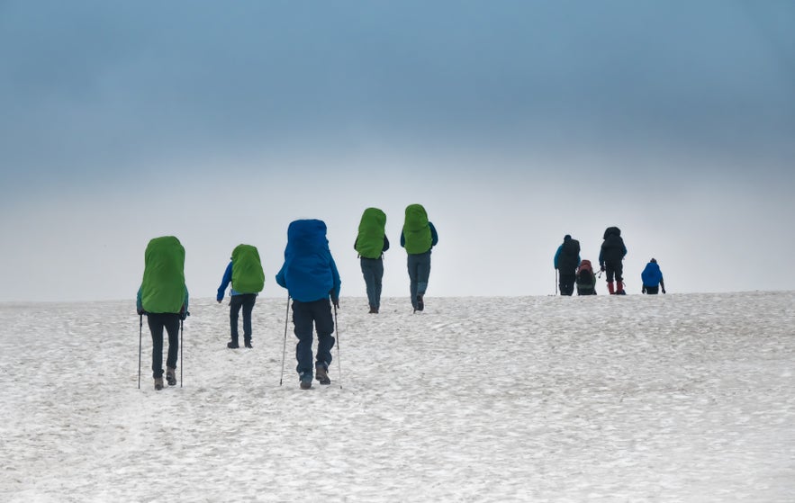 Hikers walking towards the Hrafntinnusker Mountain Peak in Iceland’s Highlands.