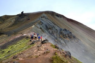 Hikers exploring the colorful geothermal landscape of Landmannalaugar in Iceland’s Highlands.