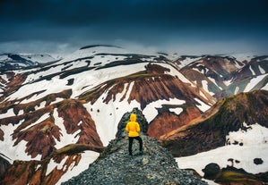 A hiker enjoying the snow-patched mountains of Landmannalaugar in Iceland.