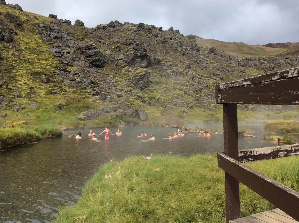 Besøgende i Landmannalaugar nyder et bad i en varm kilde om sommeren i Island.