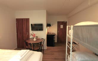 A family-style room at Day Dream L23 Guesthouse includes a double bed, bunk bed, TV, dining table, kitchenette, and wooden doors