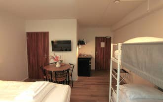 A family-style room at Day Dream L23 Guesthouse includes a double bed, bunk bed, TV, dining table, kitchenette, and wooden doors