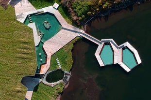 A birds eye view of the Vok Baths in East Iceland with two hot pools built into the lake and another next to the lake shore.